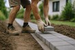 © The Little Hut - Person Laying Down Paving Stones on Garden Path Outdoor Environment Green Trees House Backyard Landscape Construction Workers