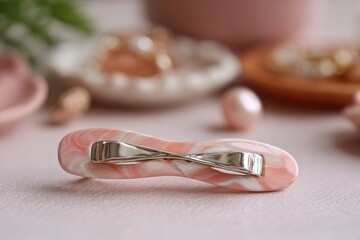 Poster - Accessory made of pink marbled design with silver clasp showcased in a softly lit setting with decorative elements around