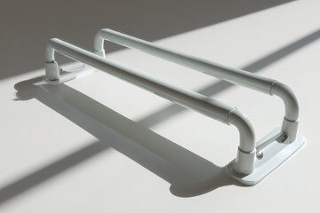 Poster - White handrail positioned on a light-colored surface with shadows casting a dynamic pattern during daytime