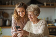 © Anton - Teen teaching grandma how to use smartphone