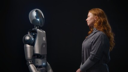 Fototapete - Futuristic Human-Machine Concept: Visualization of Young Woman Speaking with High-Tech Humanoid Robot. Symbol of Connection, Collaboration and Harmony Between Humanity and Artificial Intelligence.