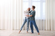 © New Africa - Happy young couple dancing together at home