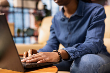 Poster - Person at home browsing internet on laptop and researching information online, accessing websites and reading articles while she sits on the couch. Find data relevant to work tasks.