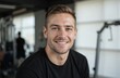 © Pete - Smiling young man in black t-shirt, fitness gym background. Healthy lifestyle, gym workout, personal training. Confident, happy guy, athletic build, sports enthusiast. Represents fitness goals,