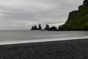 Wall Mural - Overcast day view over Reynisdrangar rock formation, Iceland.