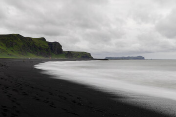 Wall Mural - Cloudy view of black sand beach in Vik during the day.