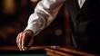 © Studium L&M - Dealer placing roulette ball on table under casino lights, gambling concept