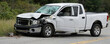 © Pete - White pickup truck damaged from accident parked roadside. Significant front impact damage, shattered windshield glass. Vehicle appears wrecked after collision, showing metal debris, shattered glass.