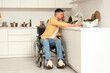 © Pixel-Shot - Young man in wheelchair washing vegetables at home