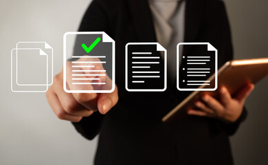 Poster - Businesswoman holding a tablet while pointing at a document with a check mark standing out from other types of documents