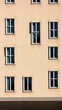 © alisa family - Architectural facade with multiple windows, showcasing building design in warm natural sunlight.