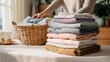 © lorenzo PV - A person folding a neat stack of clean, fresh laundry on a table, a domestic chore concept.