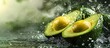 © tetxu - Fresh avocado cut in half with water drops splashing on a green background