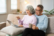 © Fahng - Retired Couple  Having Morning Coffee Together. surfing internet while resting in livingroom.