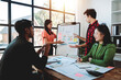 © Dino - Brainstorming of young modern group. Team meeting to achieve goal. Business people discussing finance business and analysis. Teamwork concept in modern office. Calculating personal tax for client.