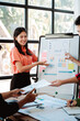© Dino - Brainstorming of young modern group. Team meeting to achieve goal. Business people discussing finance business and analysis. Teamwork concept in modern office. Calculating personal tax for client.