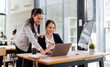 © David - Business asian women Reviewing Documents, Two business meticulously reviewing a stack of documents, highlighting the details and precision in work.