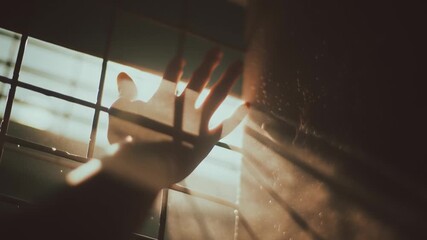 Poster - Hand reaches out to dusty sunlight illuminating a dark space during the late afternoon hours
