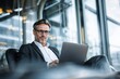 © ttonaorh - Mature professional man using laptop in modern office lounge, portraying remote work, business confidence, and digital productivity.