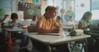 © Framestock - Elementary School Students Sitting at Desks, Writing Exam or Lecture on Geography or Science in Modern Classroom. Female Teacher Walking and Controlling Young Boys and Girls During School Test Process