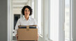 © Al - A determined businesswoman navigating a bright corridor, clutching a cardboard box full of important documents, signaling a life transition.