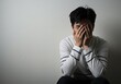 © AdityaGM - Young Man Hiding Face in Despair Against a Light Gray Background