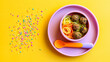 © ABF_MATEO - Colorful kids meal with pasta, meatballs and sprinkles, a vibrant and appealing way to make food fun for young children.