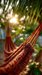 © ABF_MATEO - Relaxation in nature: Close-up of a woven hammock hanging beneath a palm tree, bathed in the warm glow of the setting sun.