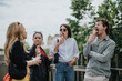 © qunica.com - A group of young friends stands outdoors enjoying ice cream cones and chatting happily.