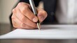 © ng-TDRD - A hand holding a pen writes on a document, symbolizing professionalism and the act of signing contracts or legal agreements.