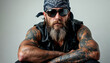 © abu - Close-up portrait of a rugged biker with tattoos and leather vest on a bright white background.