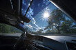 © john - Reflective sunshade protecting car interior from sunlight and heat through front windshield on a bright summer day