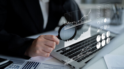 Poster - A business professional uses a magnifying glass to analyze stock market trends displayed on a laptop, showcasing innovative data visualizations in a modern workspace. Impute