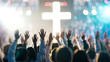 © Sarfraz - Congregation raising hands in worship towards a glowing cross symbolizing faith, hope, and spiritual connection during a powerful service.