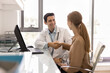 © fizkes - Cheerful handsome Hispanic physician man shaking hands with female patient in hospital office, smiling, laughing, congratulating on perfect health, good medical test results after checkup