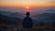 © Annette - Teenager sitting alone at the top of a hill at sunset. He is listening to music through his headphones.
