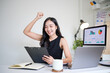 © wattana - Excited businesswoman cheering with success after achieving her goal in the office.