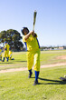 © Wavebreak Media - Man in baseball uniform wearing batting helmet swinging aluminum bat on grass field with teammates