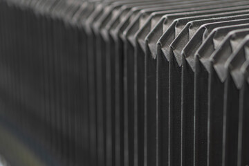 Poster - Close-up of grey, metallic structure with angular protrusions, uniform texture, and subdued lighting