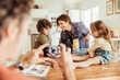 © Marko Geber - Happy young family taking a photo with a smartphone while being messy and baking with flour at home in the kitchen