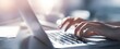 © MP Studio - The focused hands typing on a laptop in a modern workspace.