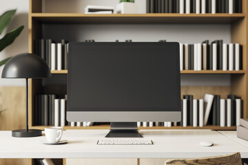 Poster - Modern desktop computer mockup on white desk with lamp, cup, and bookshelves in home office interior, front view with blank screen. 3D Rendering
