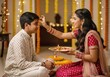 © Stockphotosbysumit - Sister applies tilak to her brother on Raksha Bandhan Indian festival