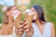 © we.bond.creations - Two women enjoying ice cream cones while relaxing in a sunny park, sharing smiles and laughter during a warm summer day