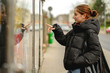 © tan4ikk - Happy Girl Reading Poster Against Blurred Street Background