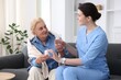 © New Africa - Nurse giving glass of water and pills to senior woman indoors. Home health care service