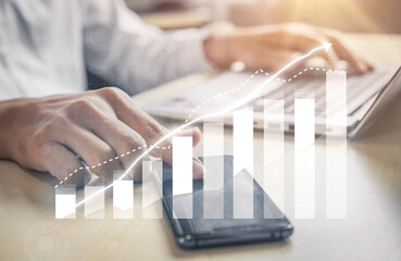 Poster - A businessman actively engaging with a smartphone and laptop in a modern office setting, showcasing rising graphs that represent success and growth. Impute