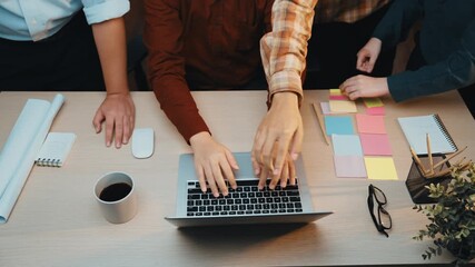 Poster - A diverse team collaborates in a modern office setting, interacting around a laptop, with coffee, notebooks, and colorful sticky notes scattered across a wooden desk. SACTR