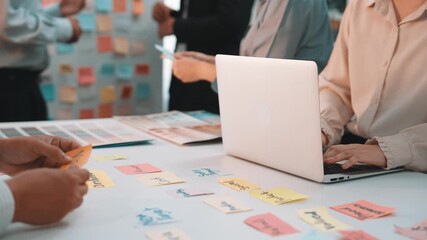 Poster - A vibrant office scene showing diverse professionals collaborating at a desk, using sticky notes and a laptop to share ideas during a brainstorming session. SACTR