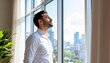 © True Stock - Middle Eastern man standing near an open window, taking a breath of fresh air to reset and refresh during a workday break